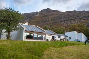 a house on a hill with mountains in the background at Torridon Youth Hostel in Torridon