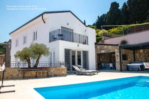 a villa with a swimming pool and a house at Gloria Holiday - Casa Bianca in Piran