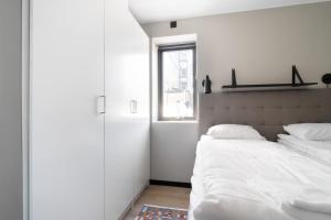 a white bedroom with a large bed and a window at View Studios in Åre