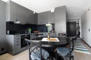 a kitchen with black cabinets and a black table and chairs at View Studios in Åre