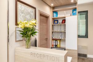 a vase of flowers on a table in a hallway at Apartments Grifone Lux in Herceg-Novi
