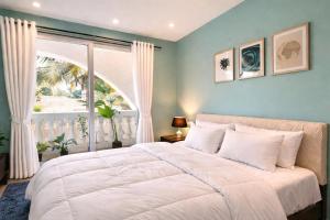 a bedroom with a large bed with a large window at Rovio in Vagator