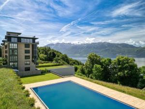 a view of a house with a swimming pool and mountains at Terrasses de Lavaux-3 Luxe & Détente Terrasse Piscine Vue Montagnes et lac in Puidoux