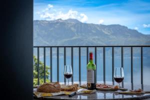 a table with two glasses of wine and bread at Terrasses de Lavaux-3 Luxe & Détente Terrasse Piscine Vue Montagnes et lac in Puidoux