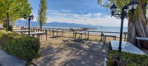 a row of tables and benches next to the beach at Plage & Montagne - Appartement familial à proximité de la plage de Préverenges in Preverenges