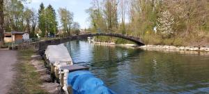 a boat traveling down a river under a bridge at Plage & Montagne - Appartement familial à proximité de la plage de Préverenges in Preverenges