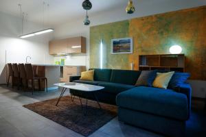 ein Wohnzimmer mit einem blauen Sofa und einer Küche in der Unterkunft Apartments At The Blue Duckling in Prag