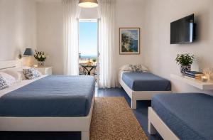 a hotel room with two beds and a television at Hotel Baia Di Puolo in Massa Lubrense