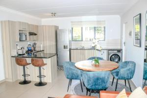 a kitchen and dining room with a table and chairs at White Orchid Luxury Apartment in Chartwell