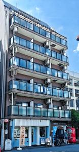 a tall building with balconies on the side of it at Sidihome 365 Apartment in Osaka