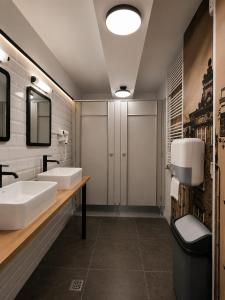 a bathroom with two sinks and two mirrors at Dzien Dobry Hostel in Gdańsk +23 photos