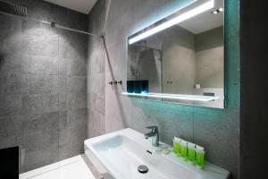 ein Bad mit einem Waschbecken und einem Spiegel in der Unterkunft Apartments At The Blue Duckling in Prag