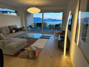 a living room with a couch and a table at Les Terrasses de Lavaux-2 Appartement de Luxe avec Vue Panoramique et Piscine" in Chexbres