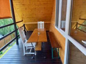 a wooden table and chairs on the porch of a cabin at Pod lasem dom letniskowy in Majdan Sopocki