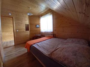 a bedroom with a bed in a wooden cabin at Pod lasem dom letniskowy in Majdan Sopocki