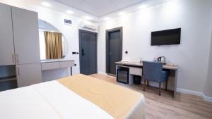 a hotel room with a bed and a desk and a television at Kıyı Hotel Restaurant in Gebze