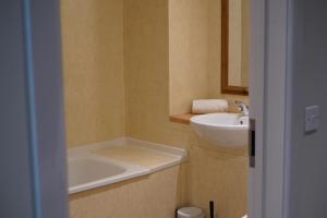a bathroom with a sink and a tub and a mirror at Meadows Hotel in Perranzabuloe +81 photos