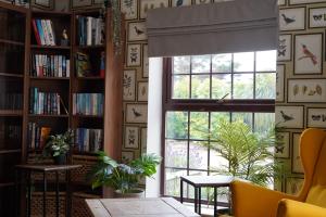 a living room with a window and a book shelf at Meadows Hotel in Perranzabuloe