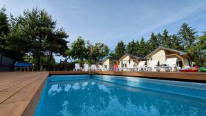 a swimming pool with chairs and a house at Malownicza Dolina in Wapnica