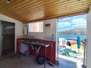 a kitchen with a sink and a view of the water at Caravan with private toilet and kitchen 2 in Grebaštica