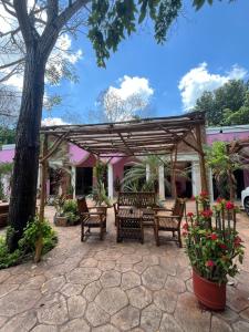 a patio with chairs and a wooden pergola at Casa Sayab Hotel Boutique in Maní
