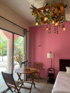 a room with a table and a pink wall at Casa Sayab Hotel Boutique in Maní