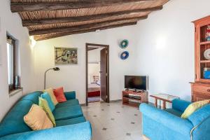 a living room with two blue couches and a tv at Casa Nomanico in Estói