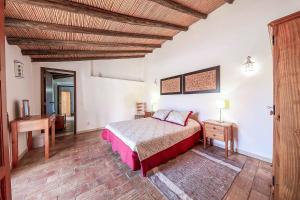 a bedroom with a bed and a wooden ceiling at Casa Nomanico in Estói +11 photos