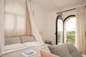 a white bedroom with a bed and a window at San Mauro Countryside Retreat with Restaurant & Wine Cellar in Momjan