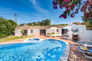 a villa with a swimming pool and a house at Casa Nomanico in Estói