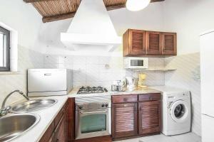 a kitchen with a sink and a stove top oven at Casa Nomanico in Estói