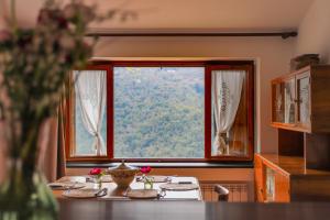 a table in a room with a large window at Come Una Volta Apricale antica dimora ligure - Parcheggio a pochi metri in Apricale