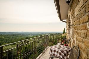 a table and chairs on a balcony with a view at San Mauro Countryside Retreat with Restaurant & Wine Cellar in Momjan