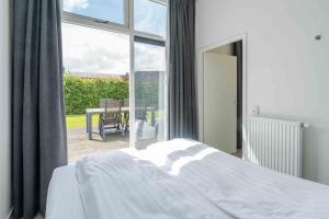a bedroom with a bed and a view of a patio at Buitenplaats Oudendijke in Ellemeet