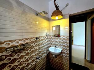 a bathroom with a sink and a mirror at Beach Way Villa in Varkala +32 photos