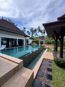 a swimming pool in the backyard of a house at Baan Thai Surin Garden in Surin Beach