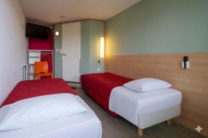 a hotel room with two beds and a red and white bed at Premiere Classe Liege / Luik in Liège
