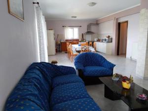a living room with a blue couch and two chairs at Christos House in Zárakes