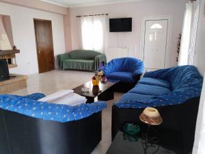 a living room with blue couches and a table at Christos House in Zárakes