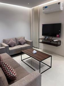 a living room with a couch and a coffee table at جودول للشقق المخدومة in Khafji +15 photos