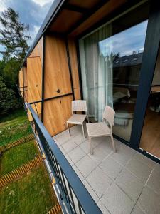 two chairs and a table on the balcony of a house at Luxury Gerlach Mountain Mezonet I in Svätý Jur