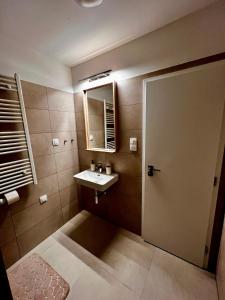 a bathroom with a sink and a mirror and a door at Luxury Gerlach Mountain Mezonet I in Svätý Jur