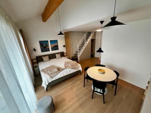 a bedroom with a bed and a table and a stairway at Luxury Gerlach Mountain Mezonet I in Svätý Jur