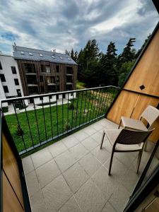 a balcony with a chair and a building at Luxury Gerlach Mountain Mezonet I in Svätý Jur