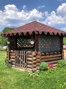 a small wooden cabin with a red roof at HOUSE Mold in Lazeshchyna