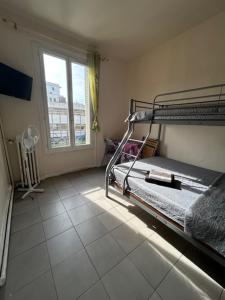 a bedroom with a bunk bed and a window at myappart - colombes in Colombes
