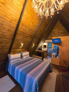 a bedroom with a bed in a wooden ceiling at Chalé Cristal Capivari in Campos do Jordão +2 photos