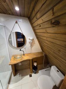 a bathroom with a mirror and a toilet in a room at Chalé Cristal Capivari in Campos do Jordão