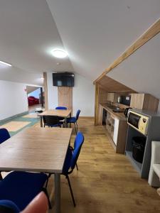 a room with tables and chairs and a kitchen at Rezydencja pod Gwiazdami in Legarda +16 photos