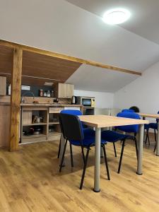 a dining room with a table and blue chairs at Rezydencja pod Gwiazdami in Legarda